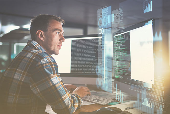 IT leader looking at cloud migration code on desktop computer