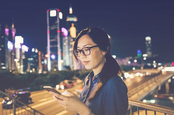 Traveler looking at app on phone via a hotel API integration