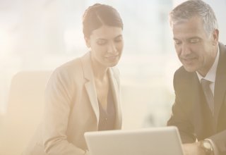 workers discuss basic MPLS configuration in front of a computer