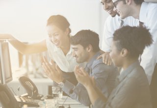 A group of smiling coworkers discussing insurance cloud solutions