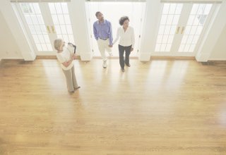 An agent with quality real estate leads shows an enthusiastic couple a house