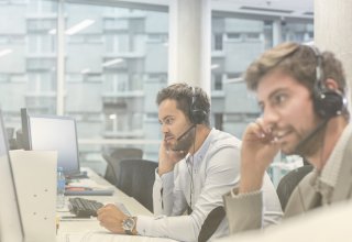 Two contact center reps use artificial intelligence in the workplace to help customers