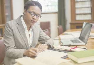 Lawyer using UC integration to communicate with clients as she studies a case strategy