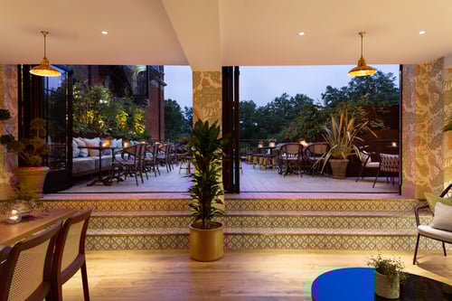 Photo of the rooftop at Pavilion, with a staircase leading outside to tables and chairs