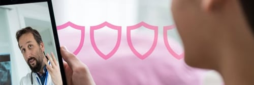 Photo of a female patient at home looking at her tablet. On the screen is a doctor discussing the patient's health situation. 