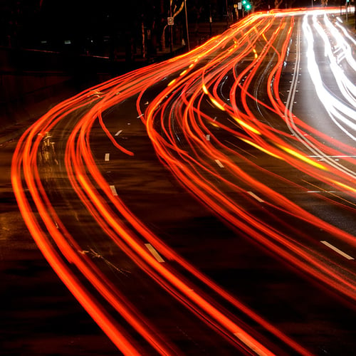 Long exposure showing the flow of multiple lanes of busy on a multi-lane urban road.
