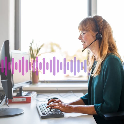 Image of a woman wearing a phone headset and looking at a computer.