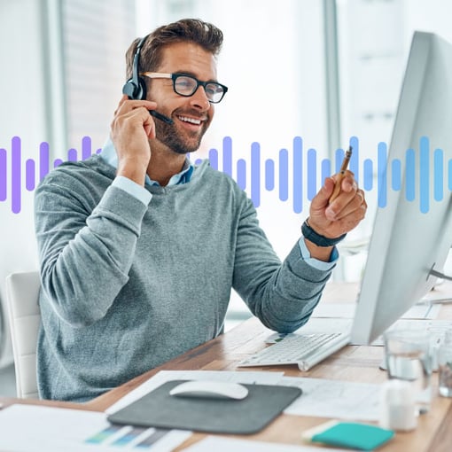 Image of man wearing a headset, talking on the phone, and looking at a computer screen