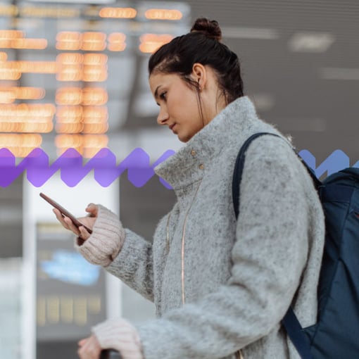 UC Work From Anywhere blog image Image of a woman using her mobile phone to work while traveling.