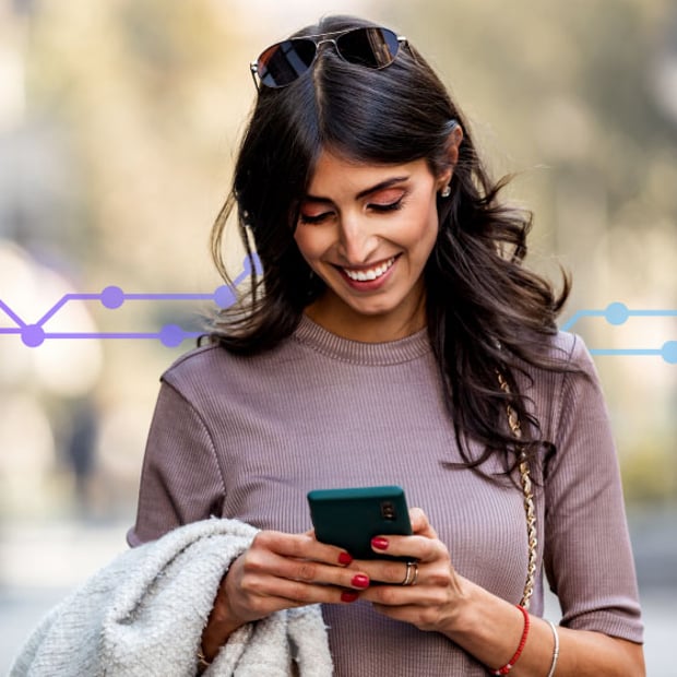 Photo of a smiling woman standing outdoors, looking at her cell phone and texting. In the background, a series of small purple icons representing ecommerce runs across the frame.