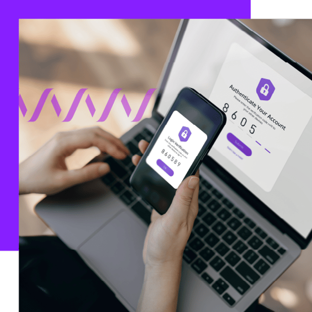 Close-up photo of hands holding a cell phone in front of a laptop computer. The phone screen shows an authentication number that is in the process of being typed into the computer.