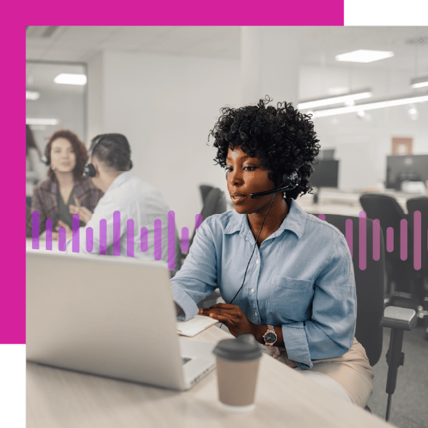 Photo of a female agent in a contact center setting working on a laptop..