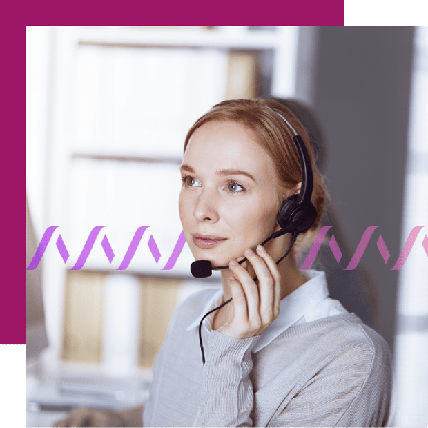 Photo of a female employee in an office setting wearing a headset.