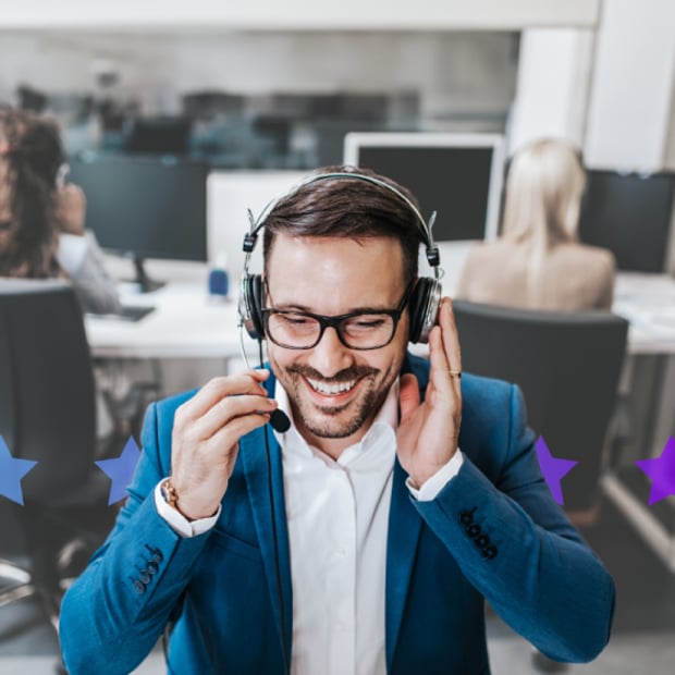 man-on-headset-article-header Image of a man seated at a desk, talking into a headset, and smiling