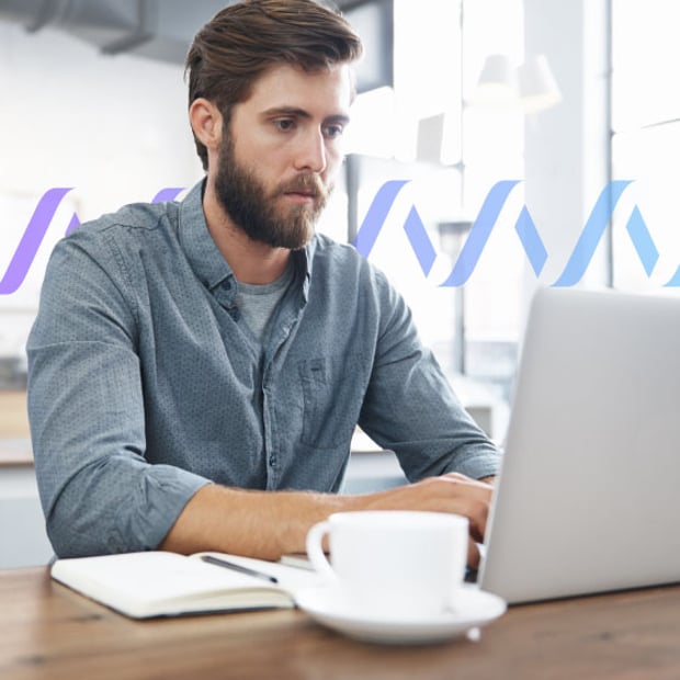 Photo of a man working on his laptop in an office or home office setting
