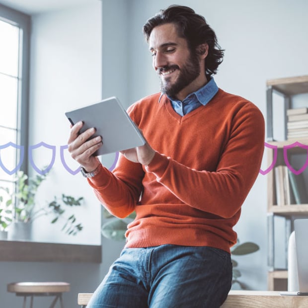 Number Insight blog Photoillustration of a white man holding a tablet and leaning against a desk in an office; a ring of security badges runs through the center of the photo indicating security
