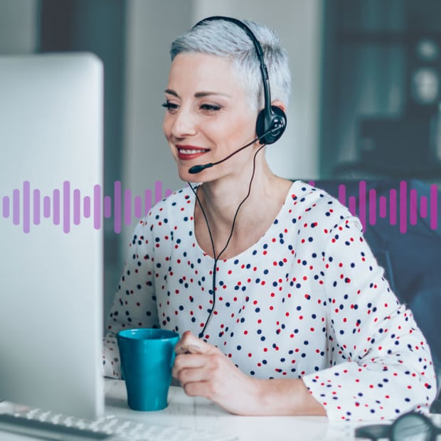 CC SEO Outbound Contact Center Blog Header Photo of a smiling agent looking at her computer monitor and talking to a customer on her phone headset. In the background, a series of small vertical purple lines run across the frame.