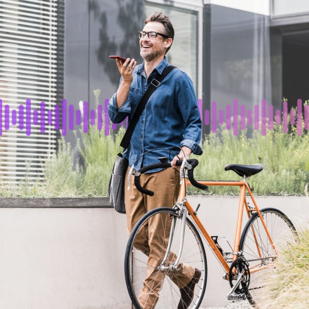 Photo of a smiling man outdoors standing beside his bicycle and having a conversation on his cell phone. In the background, a series of small purple vertical lines run across the frame, representing communication.