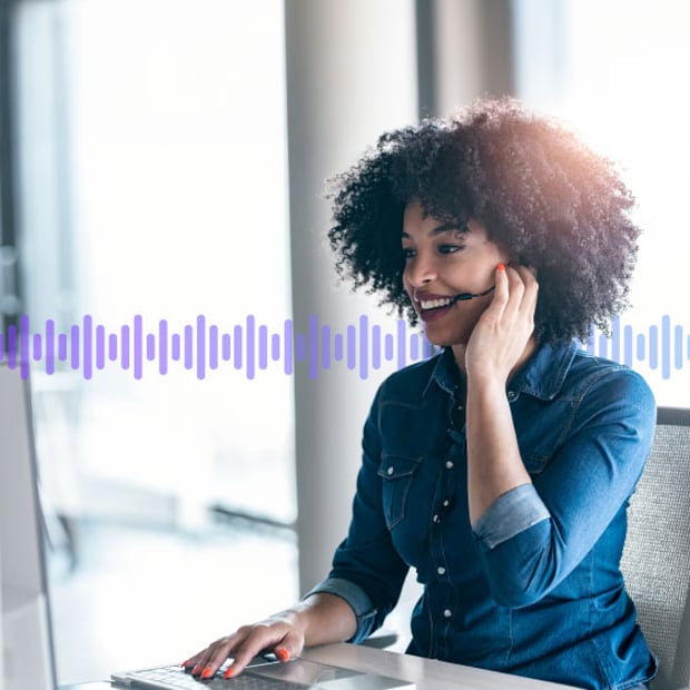 UC SEO Call Recording Blog Header Photo of smiling call center agent talking to a customer on her phone headset. In the background, a series of small gradient purple lines runs across the frame.