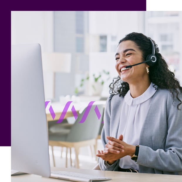 Photo of a smiling female agent wearing a headset and interacting with a customer as she looks at her computer screen.  In the background, a purple wave icon runs across the frame.