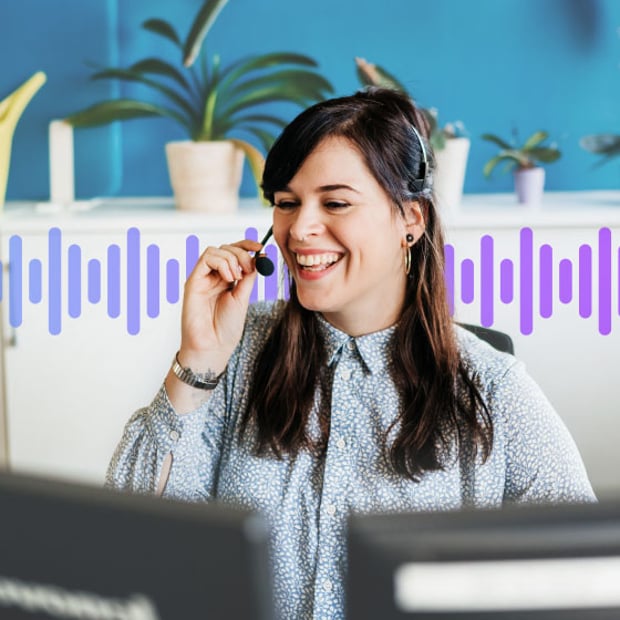 Photo of smiling female contact center agent talking to a customer on her phone.