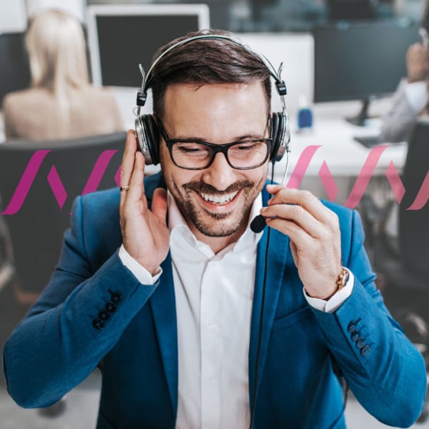 Photo of a smiling contact center agent talking to a customer through his headset