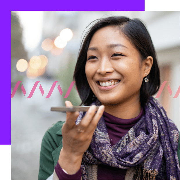 Image of a smiling woman holding up a cell phone, indicating she's on a call