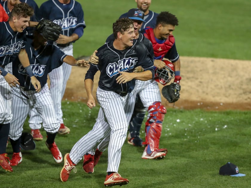 Image of Jersey Shore blue claws baseball team running off the field in uniforms after a game 