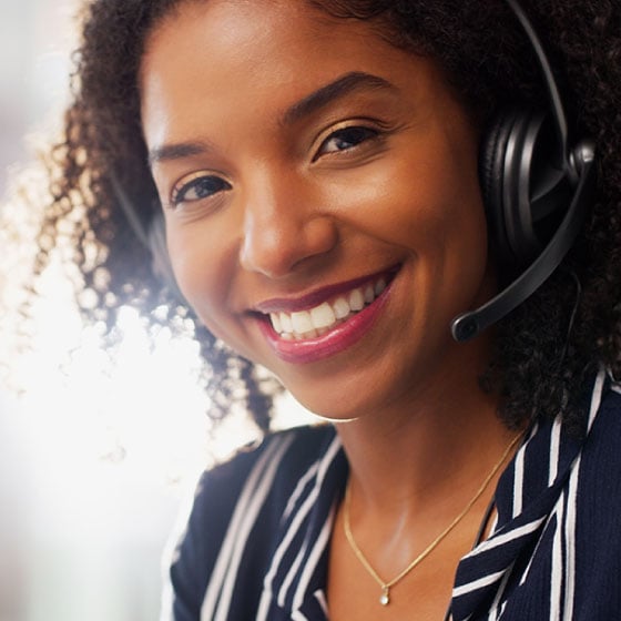 Photo of smiling woman in an office wearing a phone headset